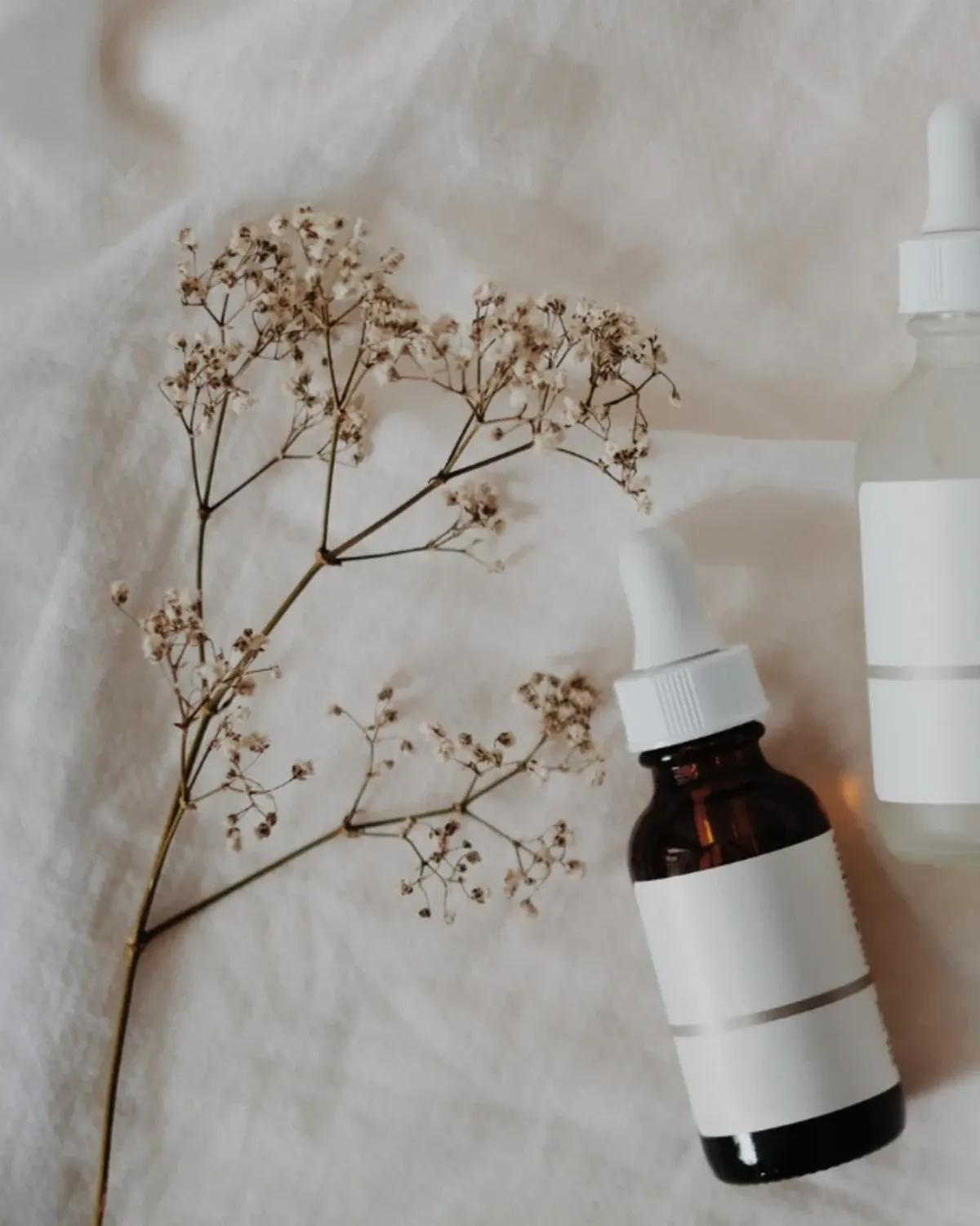 Frasco de cosmético con flores secas